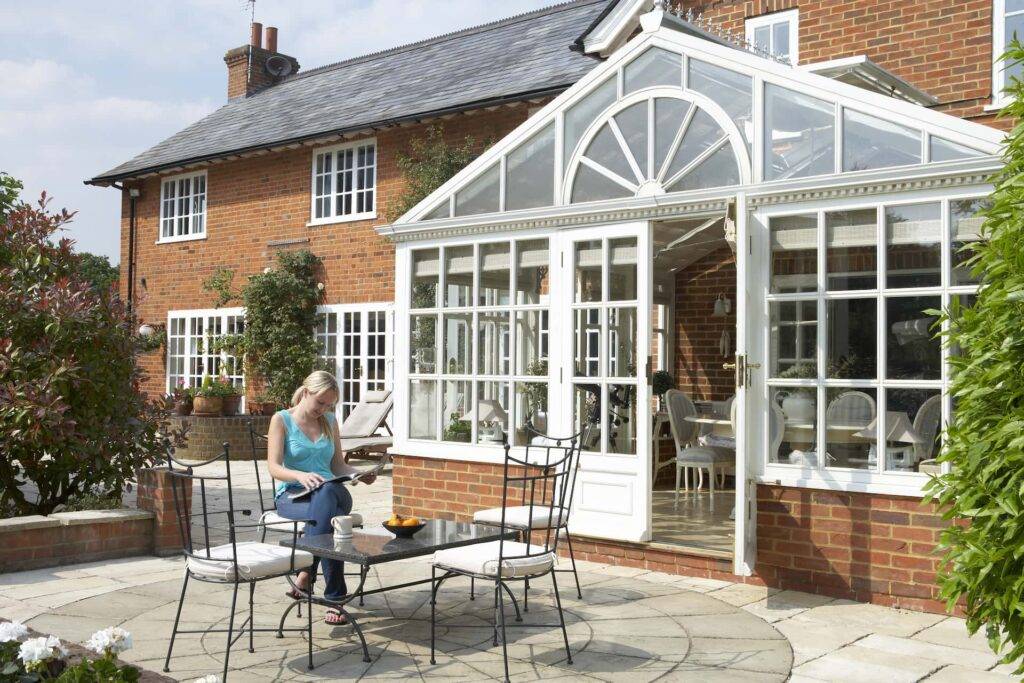A large Victorian conservatory with table and chairs outside