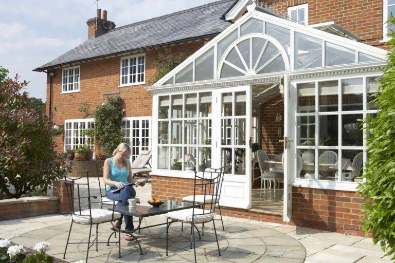A large Victorian conservatory with table and chairs outside