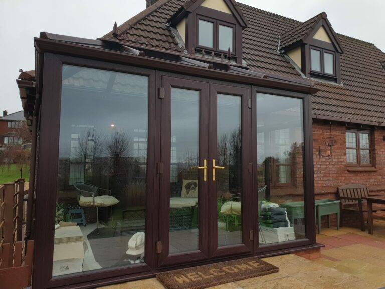A Victorian style conservatory in dark wood and gold handles
