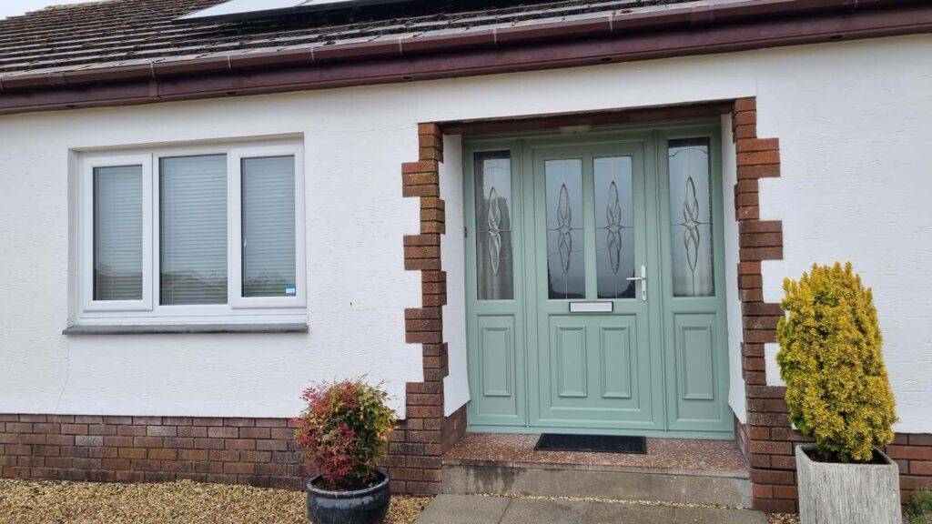 A green door with two glass panels with decoration on